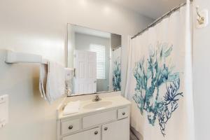 a bathroom with a sink and a mirror at A Sea Of Sand & Stars in St. George Island +18 photos