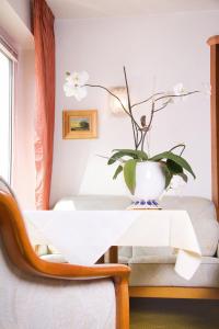 a white table with a plant on top of it at Kurhotel Kaiser in Bad Wörishofen