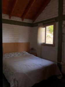 Ένα ή περισσότερα κρεβάτια σε δωμάτιο στο Casa Pehuenia, linda cabaña a pasos del Lago