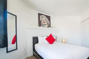 a bedroom with a white bed with red pillows at Apartments in the Heart of Miami - Port of Miami / Miami Airport in Miami