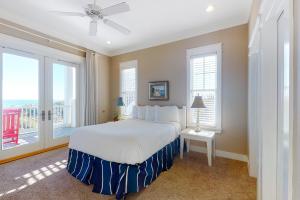 - une chambre avec un grand lit blanc et 2 fenêtres dans l'établissement Le Reve, à Île Saint Georges