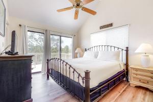 a bedroom with a bed and a ceiling fan at Our Thyme in St. George Island