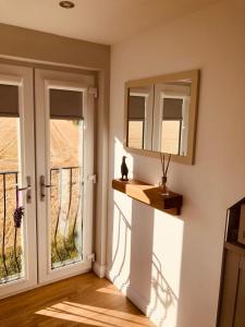 een kamer met 2 ramen en een spiegel bij 'Wardlaw View' Luxury studio apartment with stunning view in Kirkhill
