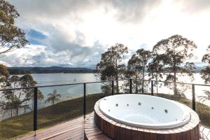 a bath tub on a deck with a view of the water at Luxé Cabañas in Guatapé
