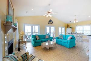 a living room with blue couches and a table at Footprints In The Sand in St. George Island