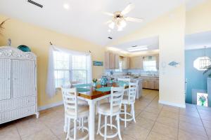 a kitchen and dining room with a table and chairs at Footprints In The Sand in St. George Island