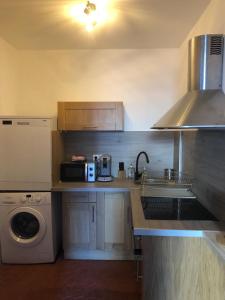 a kitchen with a sink and a washing machine at le calme à Salernes in Salernes