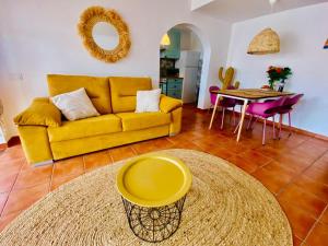 a living room with a yellow couch and a table at Golden Wave Surf Villa in Corralejo