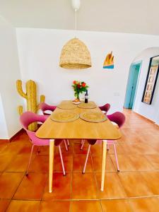 a wooden table with purple chairs in a room at Golden Wave Surf Villa in Corralejo