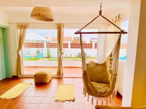 a hammock in a living room with a large window at Golden Wave Surf Villa in Corralejo