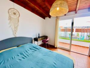 a bedroom with a bed and a desk and a window at Golden Wave Surf Villa in Corralejo +30 photos