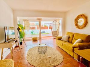 a living room with a yellow couch and a table at Golden Wave Surf Villa in Corralejo