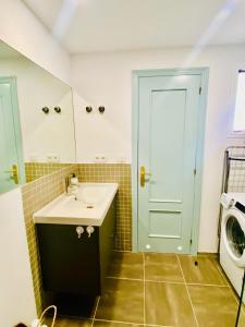 a bathroom with a sink and a washing machine at Golden Wave Surf Villa in Corralejo