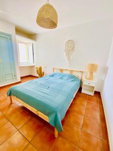 a bedroom with a bed with a blue sheet on it at Golden Wave Surf Villa in Corralejo