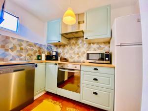 a kitchen with white cabinets and a white refrigerator at Golden Wave Surf Villa in Corralejo