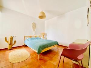 a bedroom with a bed and a chair in it at Golden Wave Surf Villa in Corralejo