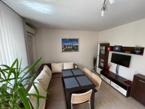a living room with a couch and a table at Apartment George in Burgas