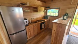 a kitchen with a stainless steel refrigerator and wooden cabinets at Ostoja Ldzań 