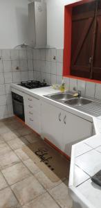 a kitchen with a sink and a stove top oven at La Maison ka in Bouillante