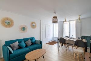 a living room with a blue couch and a table at Maison de ville en plein centre avec terrasse in Poitiers +14 photos
