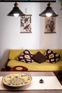 a living room with a couch and a plate on a table at Tetide Home in Palermo