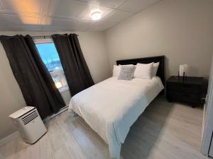 a bedroom with a large bed and a window at Le Centre-Ville in Rouyn-Noranda