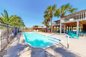 a swimming pool with a fence and palm trees at Somerset in St. George Island