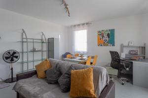 uma sala de estar com um sofá e uma secretária em The one - Cosy T2 Check-in 24/24 Fibre Parking em Blagnac