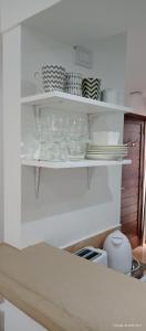 a shelf with plates and bowls and dishes on it at Calle 10 - Monoambiente in La Plata