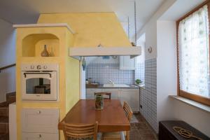 una pequeña cocina con mesa de madera en una casa pequeña en Tenuta Cascina Marenco en Gavi