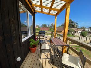 een veranda met stoelen, een tafel en een bank bij Cabaña Estudio - BBQ Cocina Estacionamiento Wifi in Quintay