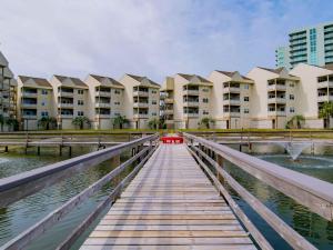 a wooden bridge over a body of water with buildings at Baywatch #C5 in Pensacola Beach