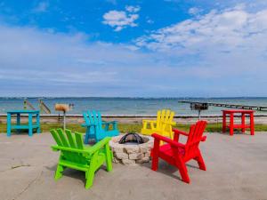 a group of colorful chairs sitting on the beach at Baywatch #C5 in Pensacola Beach