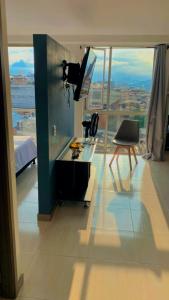 een kamer met een bureau en een televisie bij Apartasuite 01 in Pereira