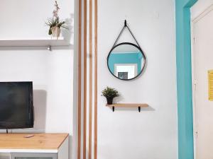 ein Spiegel hängt an einer Wand neben einem TV in der Unterkunft Apartamentos Casanostra in Salou