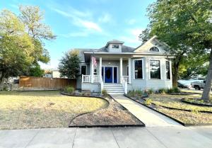 a white house with a flag in the front yard at San Antonio gem, spacious home with pool in desirable Monte Vista in San Antonio