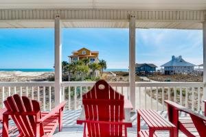 two red chairs sitting on a porch looking out at the ocean at Time Out in St. George Island