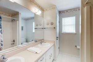 a white bathroom with a sink and a mirror at Time Out in St. George Island +14 photos