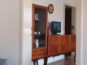 a wooden dresser with a mirror and a tv at Apartmani Emir in Visoko