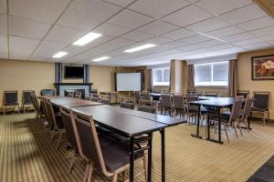 a conference room with tables and chairs and a screen at Best Western Marquis Inn & Suites in Prince Albert