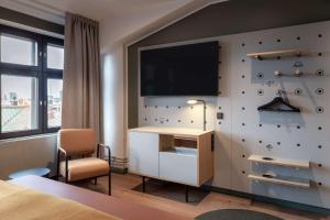 a hotel room with a tv on a wall at Scandic Helsinki Hub in Helsinki