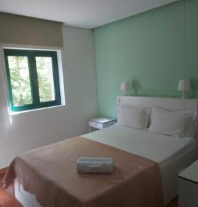 a bedroom with a large bed with a towel on it at Sobre Aguas Camping in Bragança