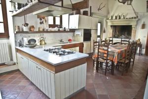 uma cozinha com uma mesa e um fogão forno superior em Villa storica di Majano em Bagno a Ripoli