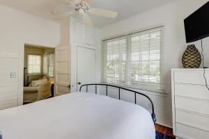 um quarto branco com uma cama e uma ventoinha de tecto em Sullivan's Island Serenity em Sullivans Island