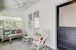 a porch with a table and chairs and a blue door at Sullivan's Island Serenity in Sullivans Island