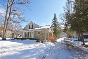 una casa blanca con nieve en el suelo en Morning Glory, en Maple City