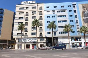 un gran edificio blanco con palmeras delante en Marchica Apartment Nador Jadid Wifi Klima, en Nador