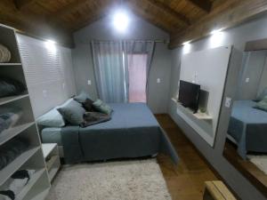 a small bedroom with a bed and a tv at Moradas Desterro, próximo ao aeroporto 23 in Florianópolis