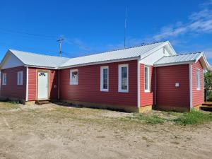 a red and white house with a white door at Beluga Beach House in Churchill