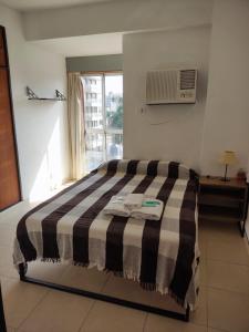 a bedroom with a bed with a black and white blanket at Departamento con buena ubicación in Corrientes